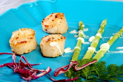 這張「扇貝佐蘆筍」的照片是三顆煎過的扇貝，搭配著烤蘆筍和一抹奶油醬，色彩繽紛，令人食指大動。