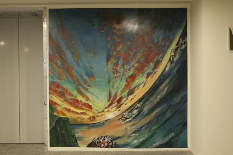 這張照片是一幅牆上的巨型壁畫，描繪了多彩的雲彩和一個巨大的行星環繞著地球。