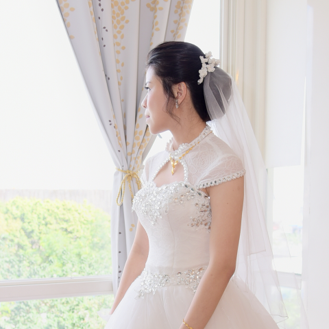 這張「婚禮」的照片是一個穿著白色婚紗的新娘，她站在窗戶邊，望著窗外。