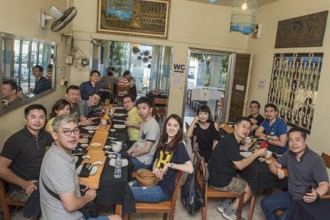 這張「一群朋友在餐廳吃飯」的照片是，幾個朋友坐在一張長桌旁，享受著美食和歡樂的時光。