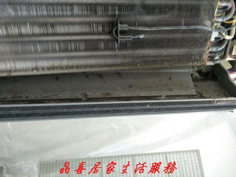 這張照片是一台需要清潔的冷氣機，因為它的冷凝器上有許多灰塵和污垢。