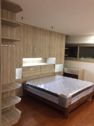 這張照片是一個臥室，最顯眼的物件是一張雙人床。床看起來很舒適，床頭板與床架皆為木質，床鋪上鋪著棉被，床邊放著一個床頭櫃。