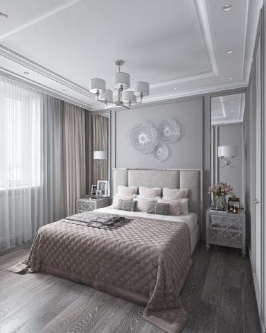 這張照片是一間臥室，重點是床。床鋪上放著柔軟的被子，床頭板是灰色，上面放著幾個枕頭。