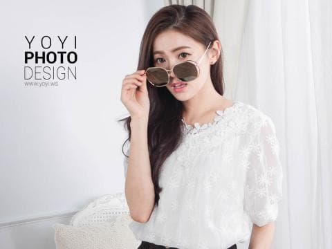 這張「時尚女性」的照片是一個年輕的女性，她穿著一件白色蕾絲上衣，戴著一副墨鏡，面帶微笑，看起來很有自信。