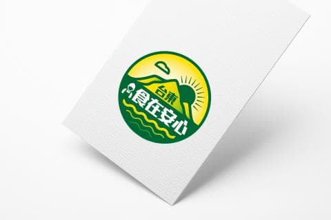 這張照片是一個綠色圓形的標誌，上面有一座綠色的山，山上有個黃色的太陽，山腳下寫著“臺灣在安山”。