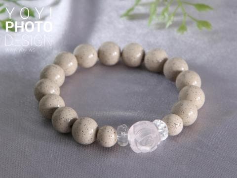 這張照片是一條由白色玉石珠串成的珠鍊，中間有一個粉紅色的玫瑰花形墜飾。