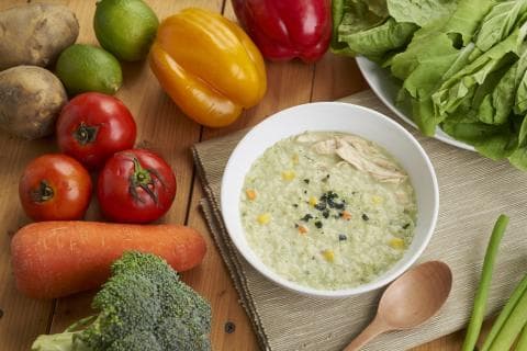 這張照片是一碗綠色的粥，上面有雞肉和一些黑芝麻。