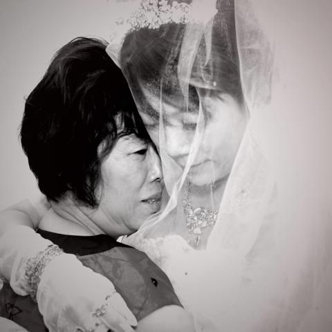 這張照片是一對母女，新娘正擁抱著她的母親，她們看起來都非常幸福。