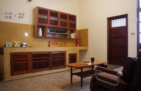 這張「廚房與客廳」的照片是一間帶有木質裝修的房子，廚房裡有木製的櫥櫃和一個水槽，客廳裡有一個沙發和一張小茶几。