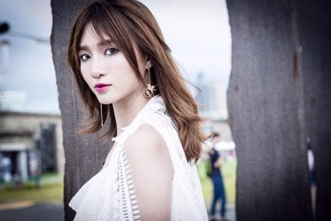 這張「女性」的照片是一個穿著白色蕾絲洋裝的女孩，她的頭髮是棕色，她戴著耳環，並且看起來很優雅。