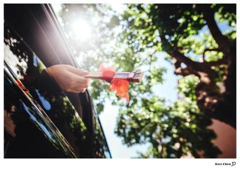 這張「有人在車裡拿著一個紅色禮盒」的照片是。
