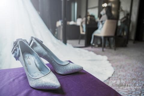 這張「婚禮照片」是兩雙水晶高跟鞋，放在紫色坐墊上。