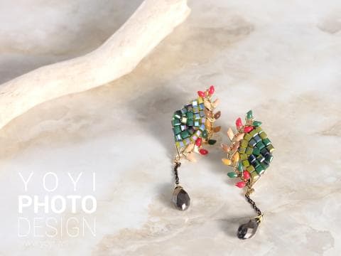 這張「耳環」的照片是兩副彩色耳環，上面飾有綠色、紅色、金色和黑色的小珠子。