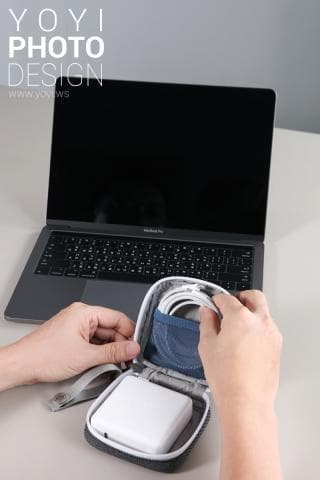 這張照片是一個灰色的小包，裡面裝著一個白色的充電器和一條白色電線。