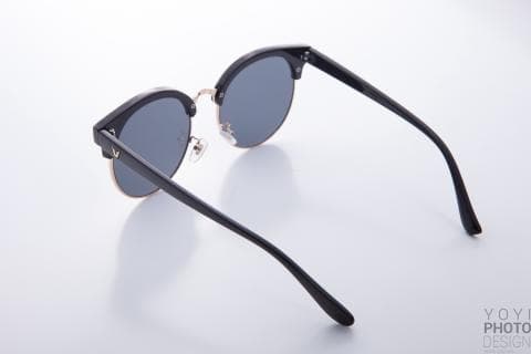 這張「太陽眼鏡」的照片是黑色的鏡框，金色的鏡腳，鏡片是深色的。