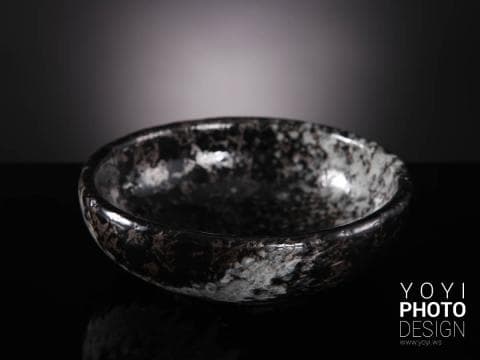 這張「黑色陶瓷碗」的照片是一個黑底白點的碗，表面光滑，顯得十分有質感。