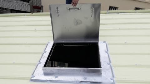 這張「屋頂」的照片是一個打開的屋頂天窗，它是由金屬製成，並有一個把手。