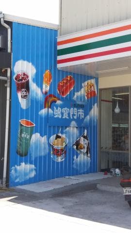 這張「超商外牆」的照片是，上面畫滿了各種飲料和食物的圖案，像是飲料、炸雞、冰淇淋等等，還有一塊寫著「超商」招牌的藍色招牌，非常可愛。