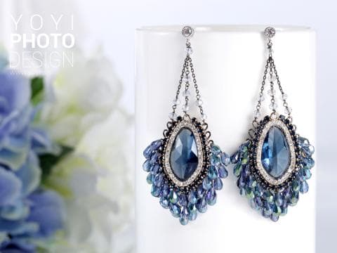 這張「耳環」的照片是一對藍色水晶和銀色裝飾的耳環，配有藍色和銀色水晶墜飾。