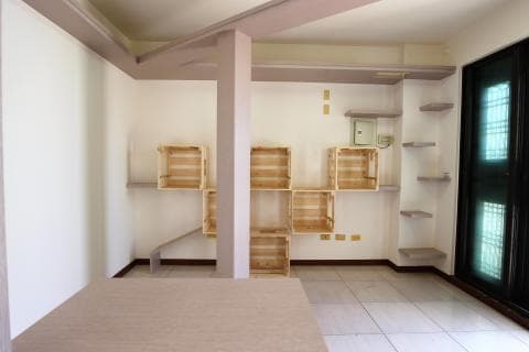 這張照片是一間室內空間，照片中最重要的部分是牆上用木箱組合成的層架，上面擺放著一些物品。