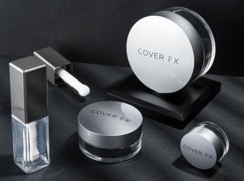 這張「化妝品」的照片是四個 Cover FX 的產品，包括一瓶透明的粉底液、一支透明的粉底液刷、一個圓形粉盒和一個圓形粉餅。