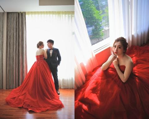這張照片是兩位穿著紅色禮服的新人在拍攝婚紗照。其中一位新人穿著一件蓬鬆的紅色婚紗，另一位則穿著一件較貼身的紅色禮服。他們都笑容滿面，看起來非常幸福。