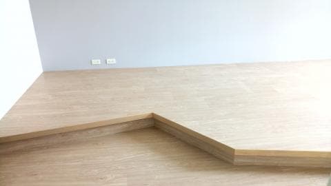 這張照片是一個房間的角落，地板上有一塊六角形的木頭地毯。