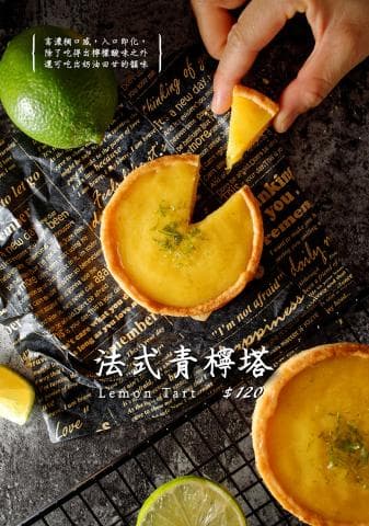 這張「檸檬塔」的照片是兩個新鮮的檸檬塔，上面有黃色的檸檬餡，看起來很美味。旁邊還有一片切好的檸檬和一顆完整的檸檬。