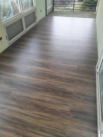 這張照片是一間房間的地板，地板是木紋的，看起來很乾淨。