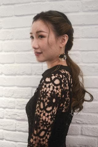 這張「一位年輕女子穿著黑色蕾絲洋裝，綁著低馬尾」的照片是。