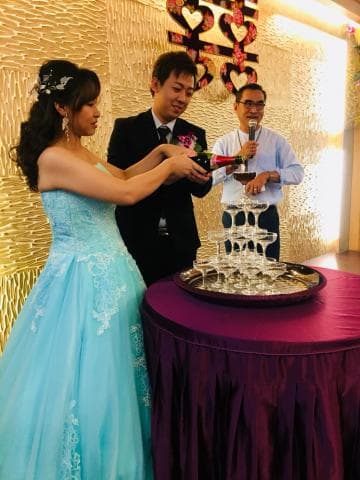 這張照片是一對新人正在進行香檳塔儀式，他們正在一起倒香檳，場面非常浪漫。