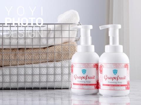 這張照片是兩瓶葡萄柚香味的起泡洗手液，放在浴室的架子上。