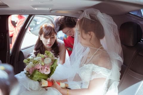 這張「婚禮」的照片是一對新人坐在車裡，新娘穿著婚紗，新郎在旁邊，新娘手裡拿著捧花。