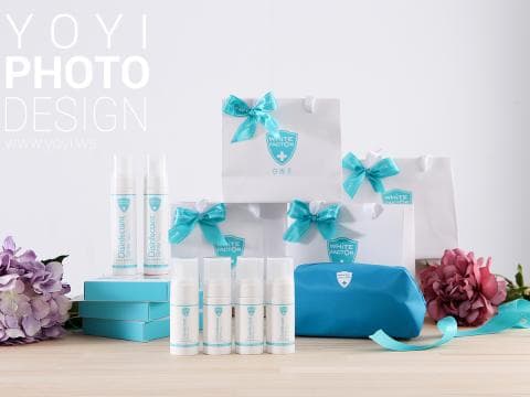 這張照片是產品包裝，有四瓶潔白牙齒的噴霧以及一個藍色的化妝包。