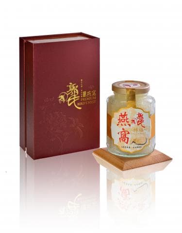 這張「燕窩」的照片是一個紅色的禮盒和一個裝滿燕窩的玻璃瓶，瓶子放在一個木頭底座上。
