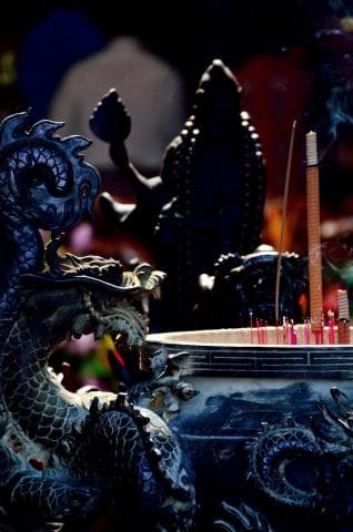 這張「龍」的照片是一條盤旋的龍，它正守著一個香爐。香爐裡有許多正在燃燒的香。