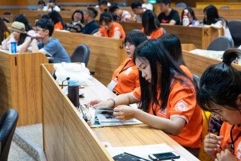 這張「學生們在課堂上認真聽講」的照片是，一群學生坐在教室的課桌上，認真聽講老師講課，他們有的在筆記，有的在思考，看起來都很專注。