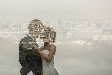 這張照片是一對新人擁抱在一起，他們的身影與城市景色重疊，營造出浪漫且夢幻的氛圍。