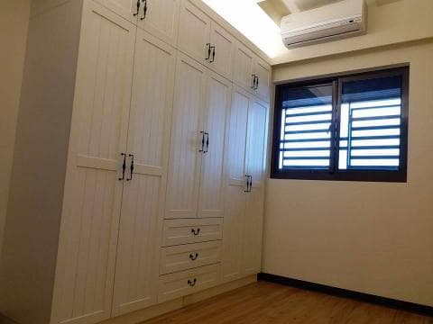 這張照片是一個房間的衣櫃，衣櫃上裝有黑色的把手，看起來很有質感。