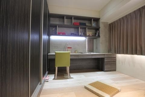 這張照片是一間書房，最主要的部分是書桌，它是由深色的木頭製成，上面放著一台電腦，旁邊還有一個綠色的椅子。书桌旁是書架，上面摆满了书籍和饰品。