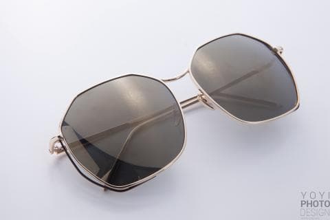 這張「太陽眼鏡」的照片是一個八角形的金色鏡框，鏡片是深褐色的。