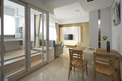 這張「現代家居設計」的照片是一間客廳，空間明亮，擁有大片落地窗和木質地板，客廳內有舒適的沙發、一張餐桌和四張椅子，透過落地窗可以看見戶外的景觀。