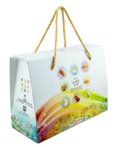 這張「禮品盒」的照片是一個用來裝堅果的禮品盒，盒子上印有各種堅果的圖案，以及「尚好」的品牌名稱。盒子有提手，方便攜帶。