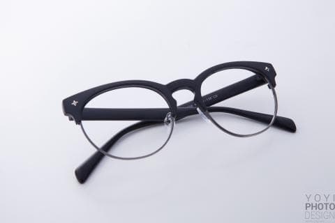這張照片是一副黑色邊框的眼鏡，鏡框設計獨特，呈圓形，鏡片是透明的，看起來很時尚。
