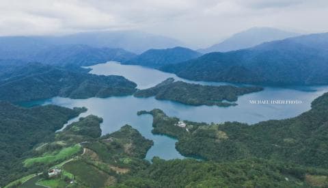 這張「高山湖泊」的照片是從高空俯瞰一個被群山環繞的湖泊，湖水清澈，周圍樹木繁茂，景色秀麗。