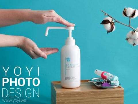 這張「消毒」的照片是一雙手正在使用消毒噴霧，背景是棉花和藍色牆壁。