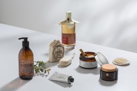 這張「沐浴用品」的照片是展示了四種不同的沐浴產品，分別是：一瓶沐浴乳、一包沐浴鹽、一塊沐浴皂和一罐身體乳。