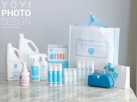 這張照片是展示著許多不同種類的保養品和清潔用品，包括洗面乳、噴霧、護手霜等等，這些產品都以白色為底色，搭配著淡藍色的點綴，看起來清新又舒服，並用了一個白色的袋子裝著，上面印著 White Factor 的字樣。