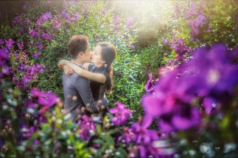 這張照片是一對情侶在一片紫色的花叢中接吻。他們看起來很幸福，周圍的花朵為他們增添了浪漫的氛圍。
