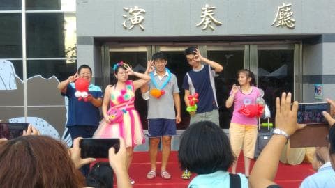 這張照片是一群朋友在戶外聚會，他們一起玩氣球，看起來很開心。